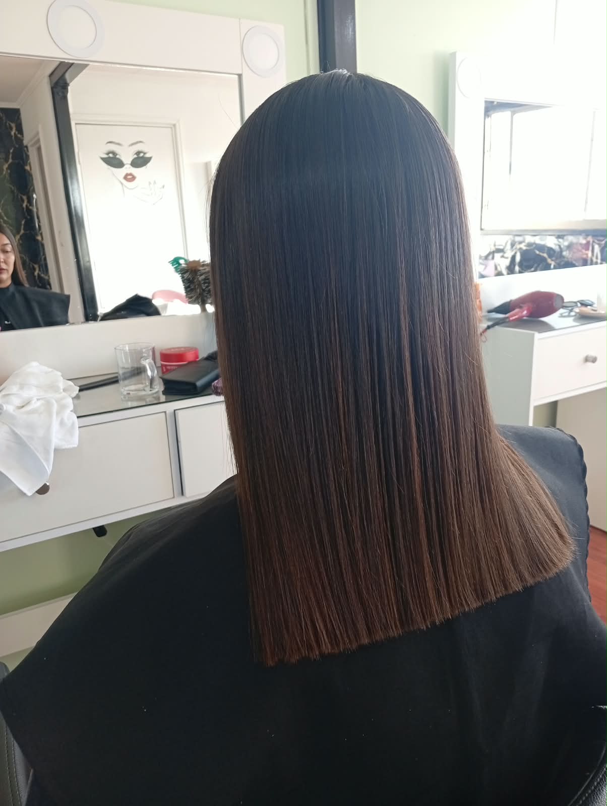 Corte recto en cabello castaño liso, visto de espaldas