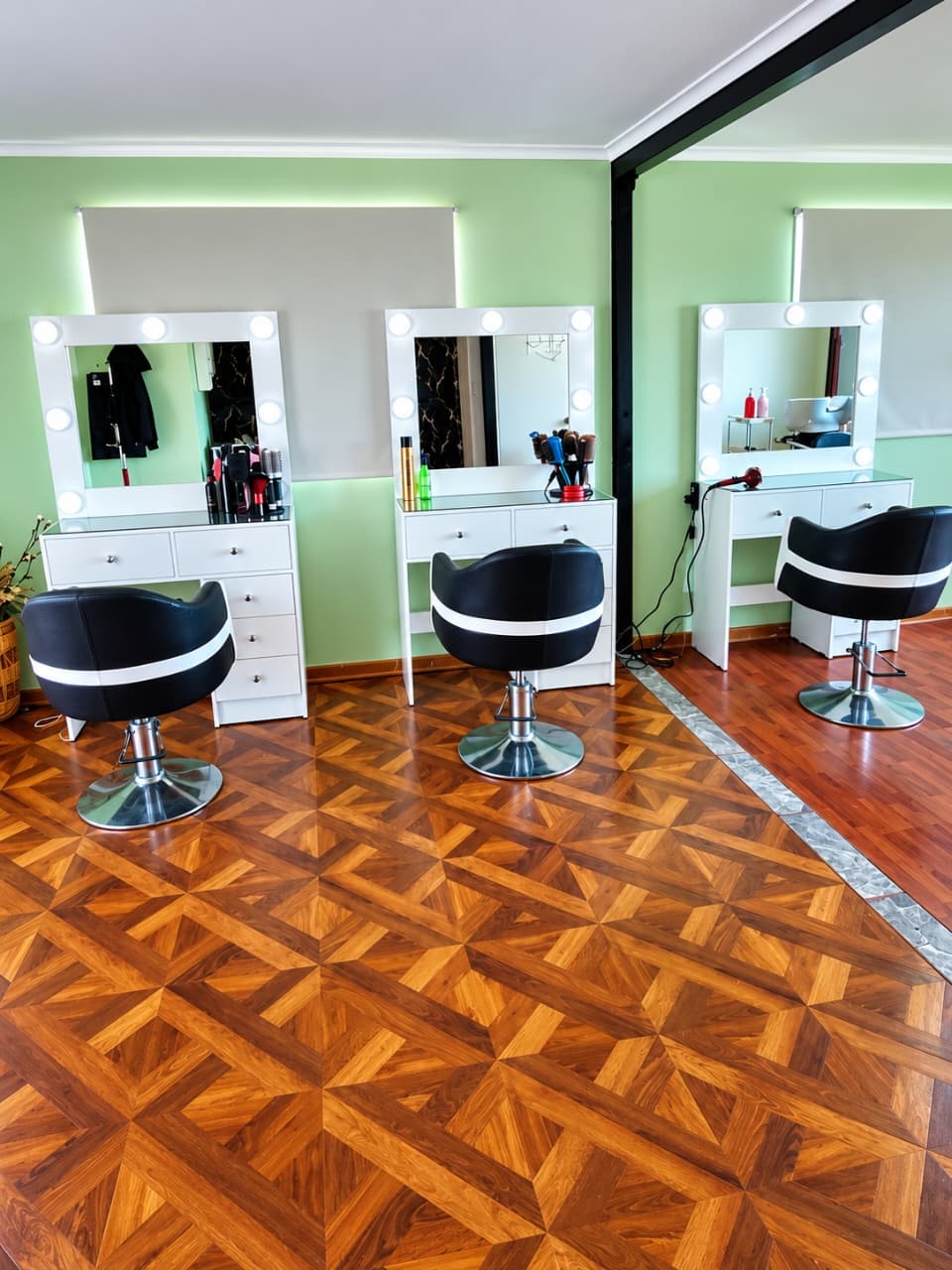 Tres puestos de peinado con espejos iluminados en Club Creativo Peluquerías