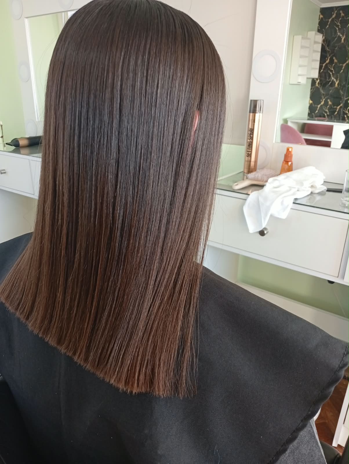 Corte recto en cabello castaño liso, visto de costado